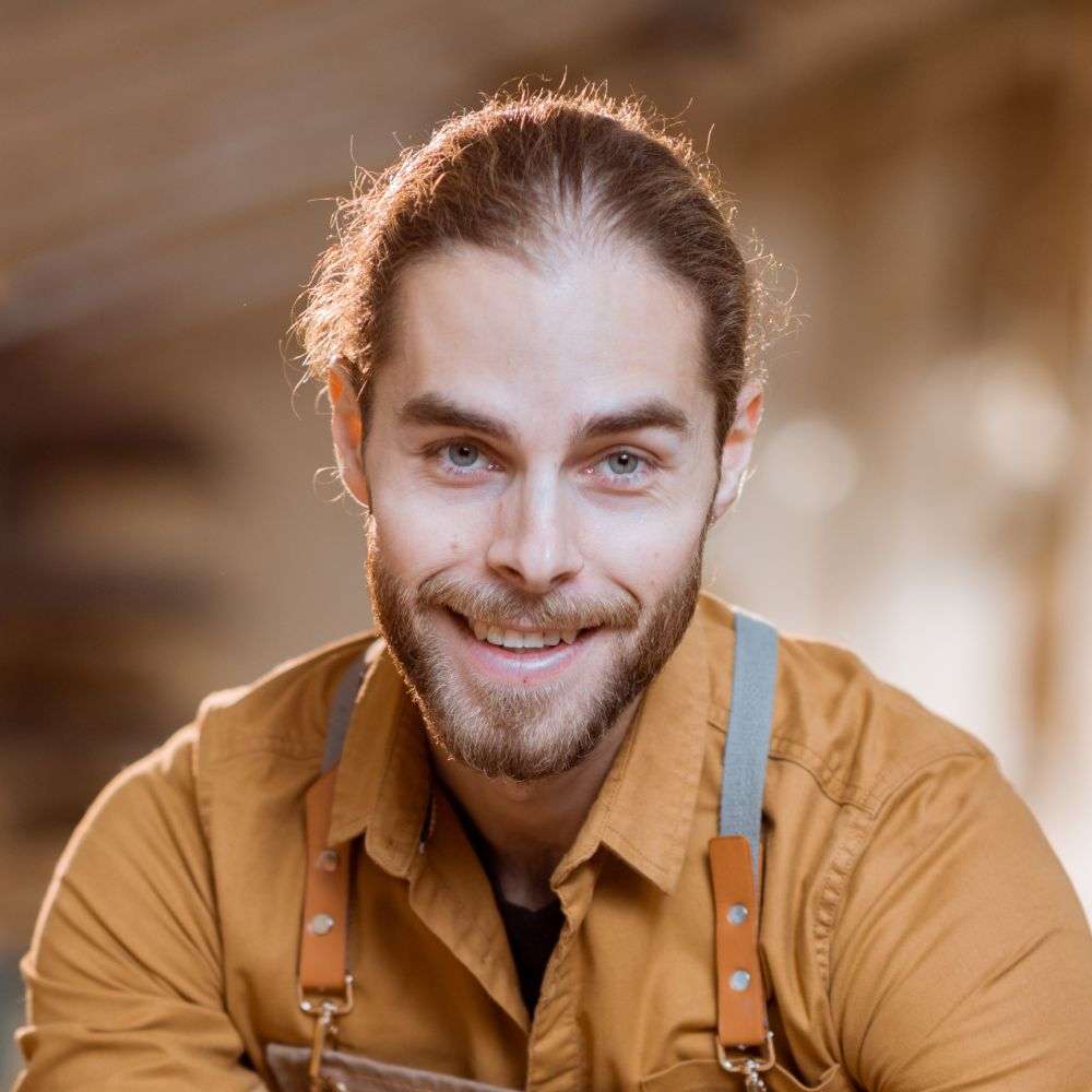 Portrait of a bearded craftsman with light eyes.